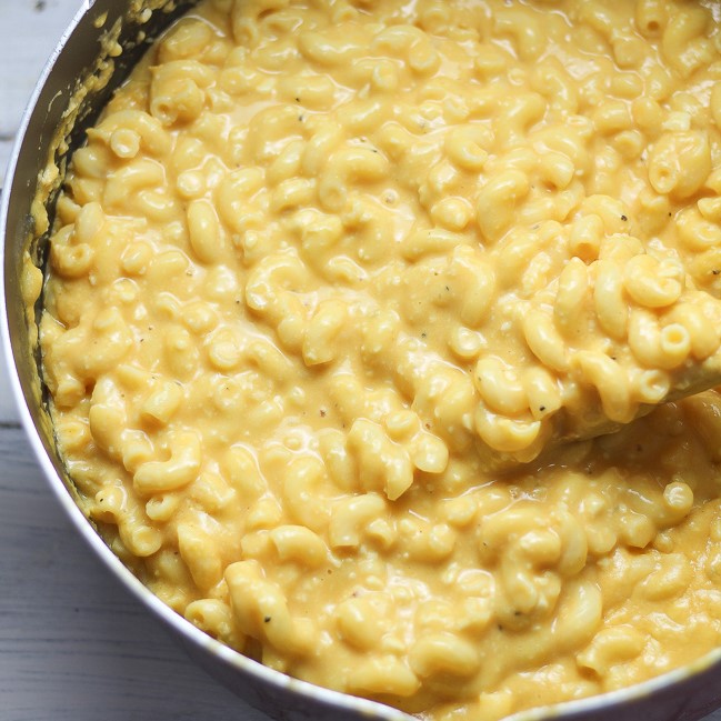creamy vegan mac and cheese in a pot with a ladle