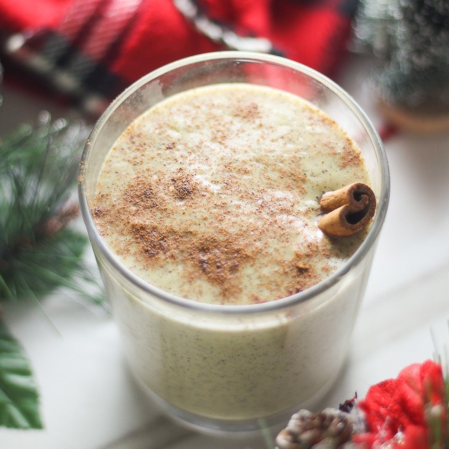 eggnog in a glass with a cinnamon stick