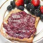 blackberry jam spread on toast next to fresh berries