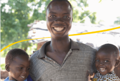 Shanu stands with his two children in Malawi