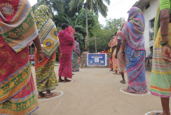 Women stand in socially distant lines to receive emergency food aid in India.