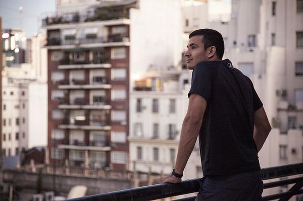 man standing on apartment balcony in city