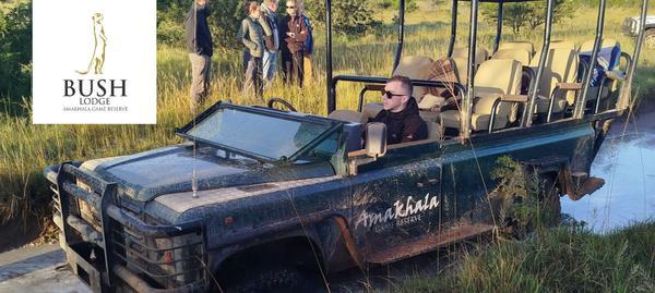 Safari vehicle driving through deep mud