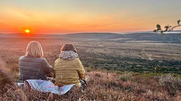 Two people enjoying the sunrise of the Amakhala Reserve