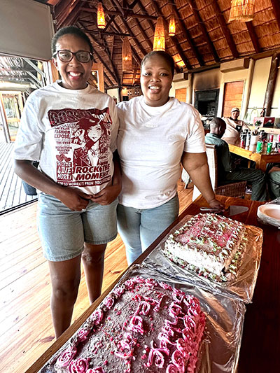 Two ladies standing in front of cake during celebrations