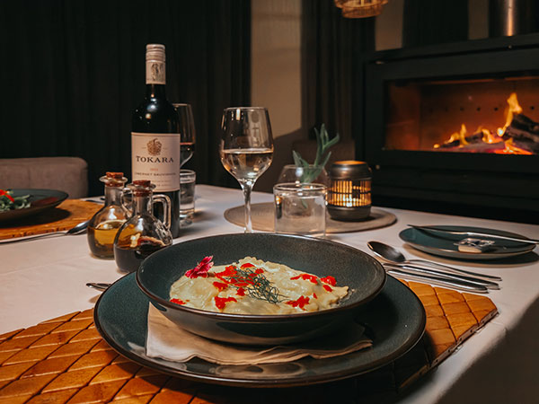 Bowl of food on table with a glass of wine