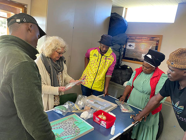 Group of people looking over the table with beading supplies