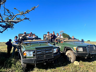 Staff group sitting in safari vehicles