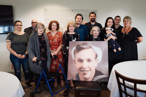 Some of the Wilbur Mitts family with his picture at the family luncheon following his funeral.
