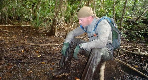 Team member, Casey Doyle, takes a break in the mangrove jungle to rehydrate.