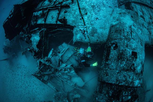 A Project Recover team diver descends onto a WWII aircraft resting site