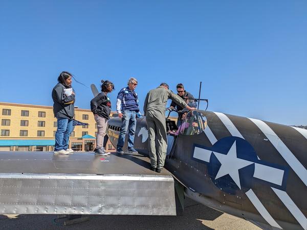 High school students get to sit in the cockpit of an old warbird.