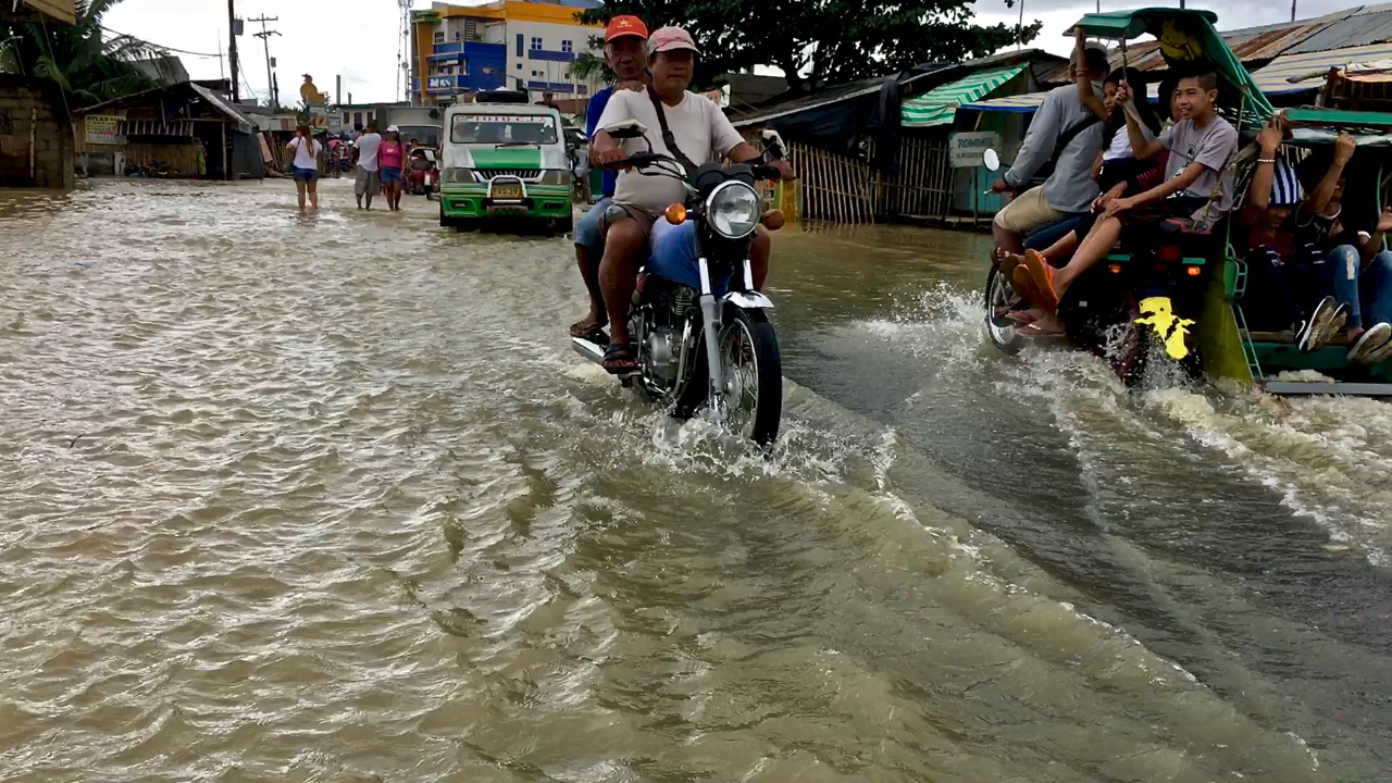 Riding through floodwaters in Balasan, Iloilo