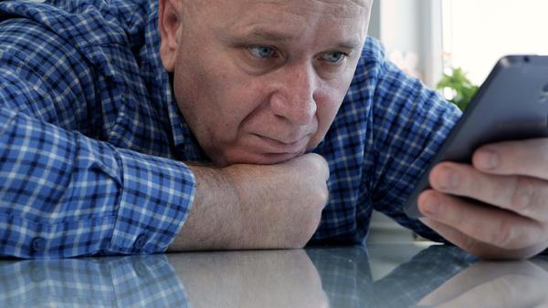 Bored man looking at cell phone
