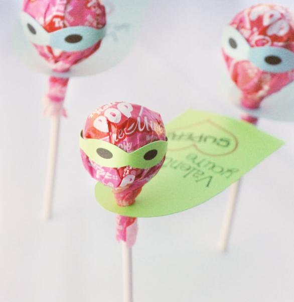 Tootsie Pop lollipop wearing a superhero cape and mask. The cape reads, Valentine, you're super!