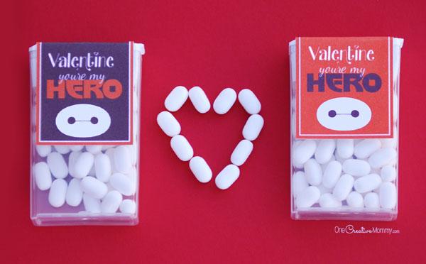 Two packages of Tic Tacs candy. Each has a paper covering the label that says, Valentine, you're my hero! There is a picture of Baymax on the front. There is a heart made of Tic Tacs between the two packages.