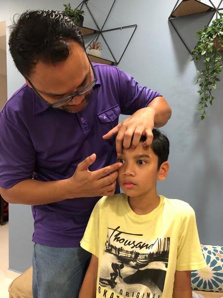Man helping son with Ortho K lens