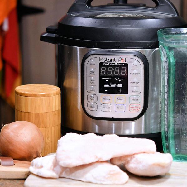 frozen chicken breasts on a cutting board in front of an Instant Pot