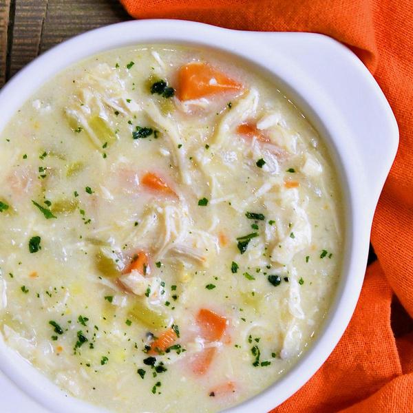 creamy chicken soup in a white, two-handled bowl