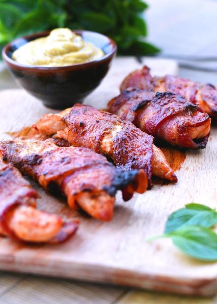 bacon chicken strips on a wooden cutting board