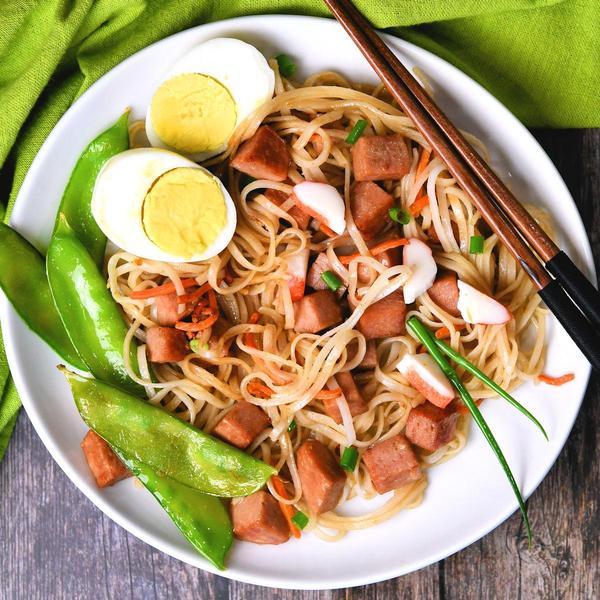 fried noodles with spam on a white plate