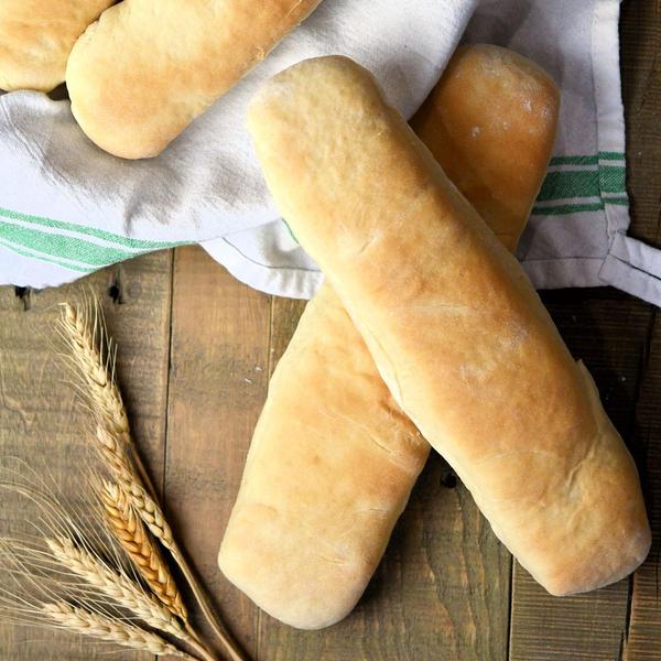 foot long homemade sandwich rolls on wooden table