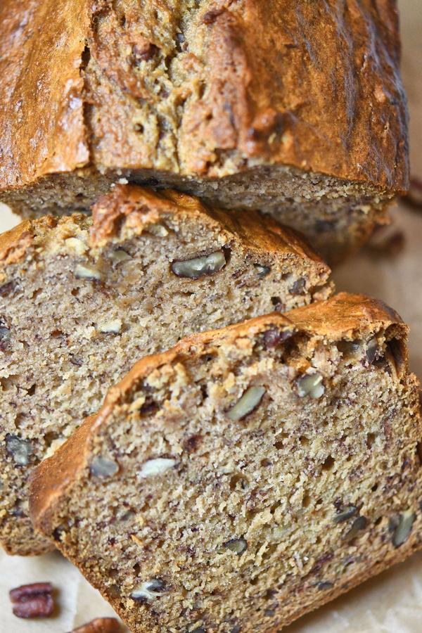 sliced banana bread with lots of walnuts on a cutting board