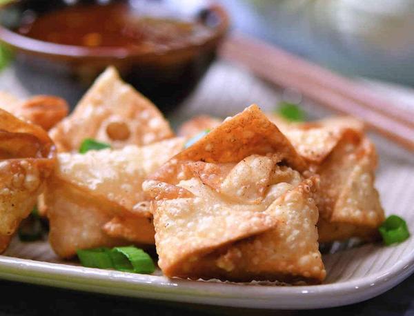 shrimp rangoon on a plate with sauce and chopsticks