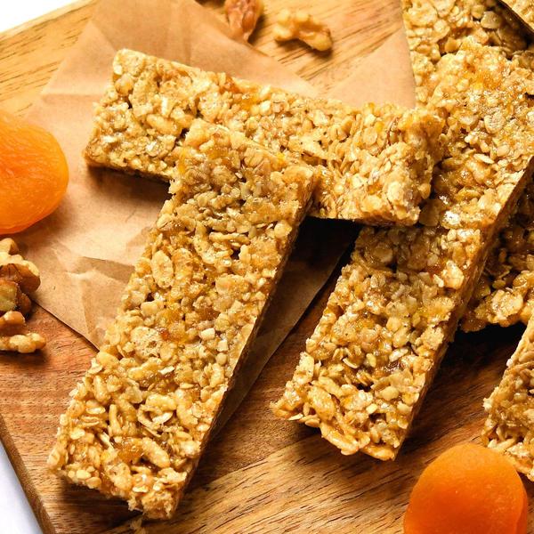several granola bars displayed on a wooden cutting board