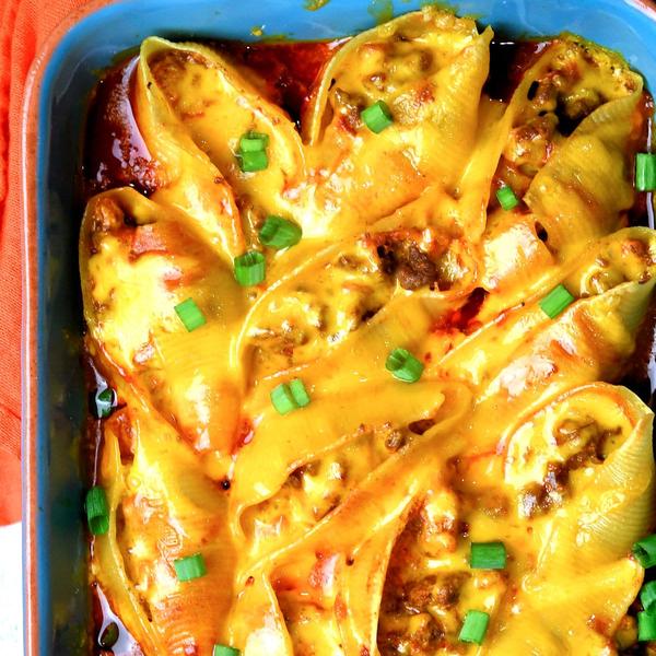 very cheesy stuffed shells in a blue baking dish