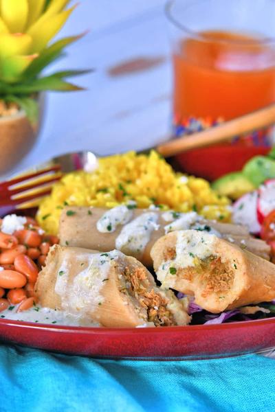 chicken tamales on a plate with rice and beans