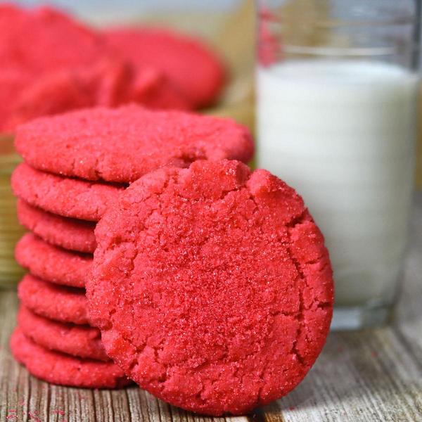 Mexican pink shortbread cookies stacked on a wooden board