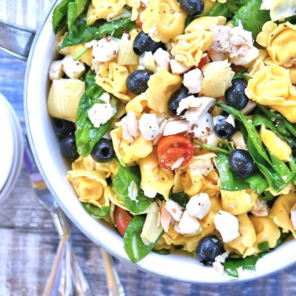 chicken tortellini salad in a large bowl on a picnic table.