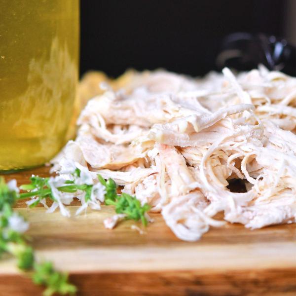 freshly shredded chicken on a wooden cutting board