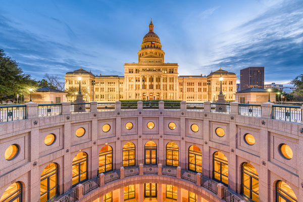 Portrait of bluebonnets in front of the Texas Capitol, which is out of focus