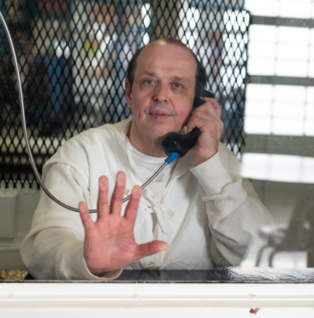 A photo of Robert Roberson on the phone behind glass at a Texas prison.