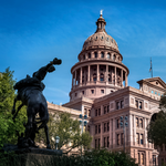 Photo of part of the Texas Capitol building among trees