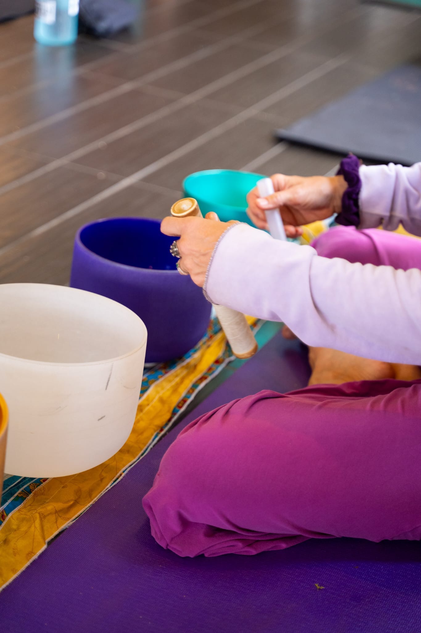 Anya Love playing turquoise, purple and frosted crystal singing bowls during a sound-healing meditation on Kauai