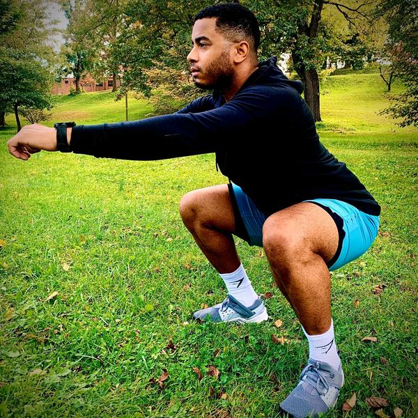 Personal Trainer Donte Collins demonstrating an air squat exercise.