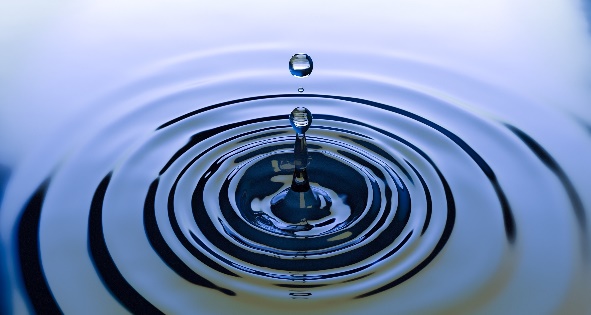 A water droplet falling into water
Description automatically generated