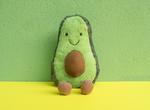 Plush toy avocado smiling, with pit for a stomach visible