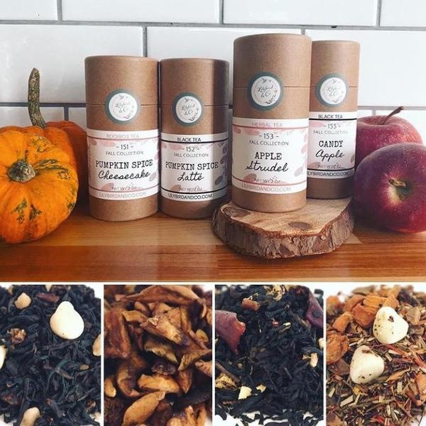 Image of 4 loose leaf teas from Lilybird on a table surrounded by apples and pumpkins. 