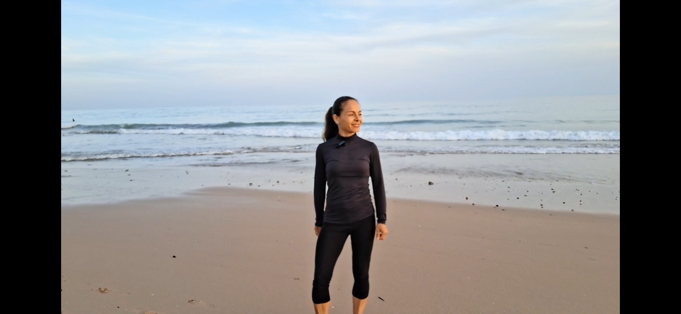 Constanza Rendon standing calm and grounded on the beach at dawn