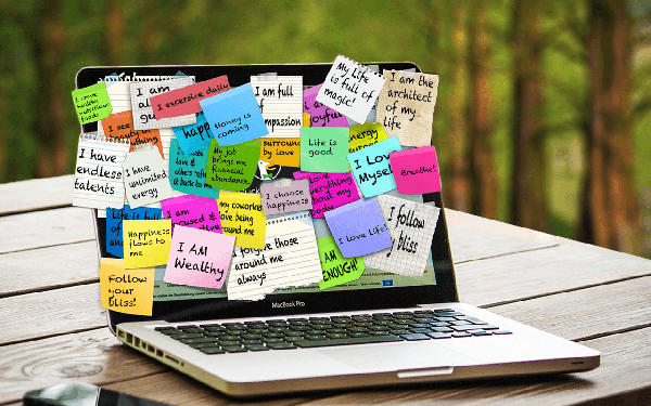 MacBook with post-it notes and written affirmations