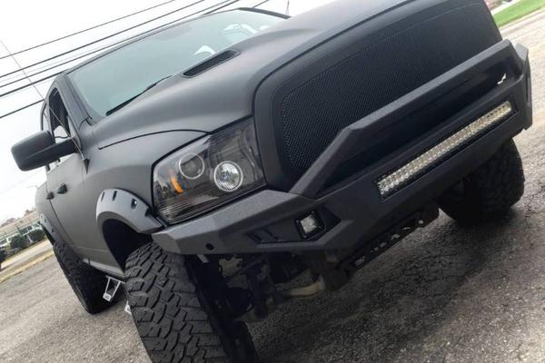Truck coated in LINE-X with aftermarket bumper and fender flares
