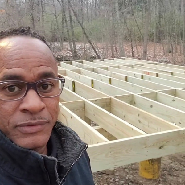 Mike Griffin, licensed Michigan builder, on a job site in front of a newly framed floor deck.
