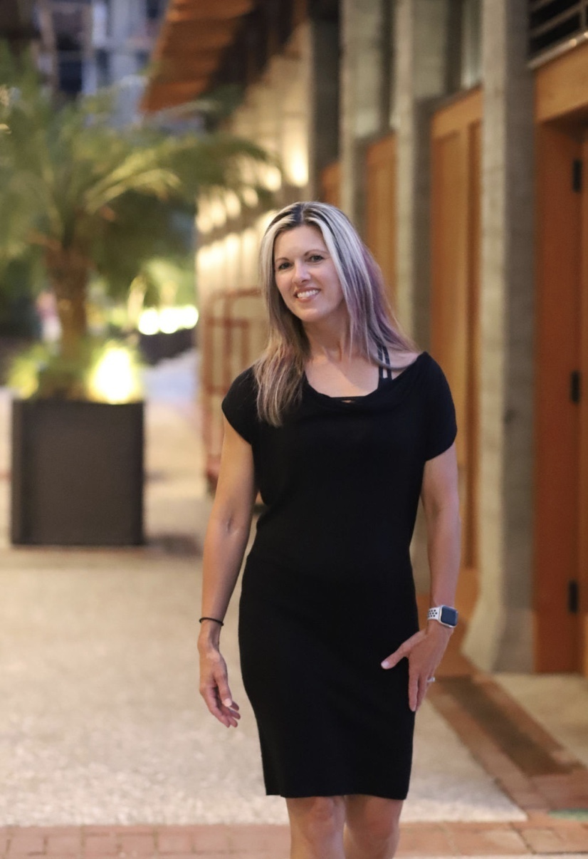 Melanie standing confidently, ready to help you find what's keeping you stuck