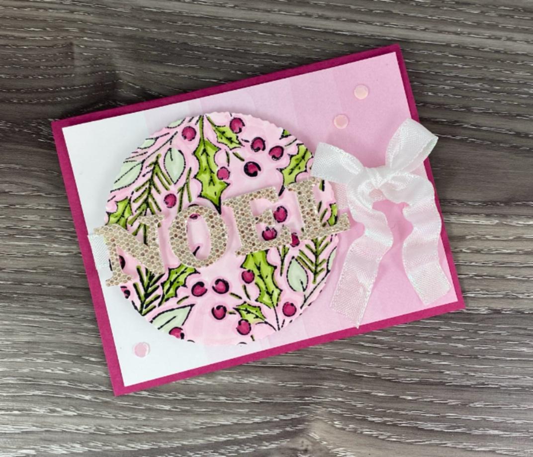 A pink and white card with a pink circle and white ribbon
            
            Description automatically generated
