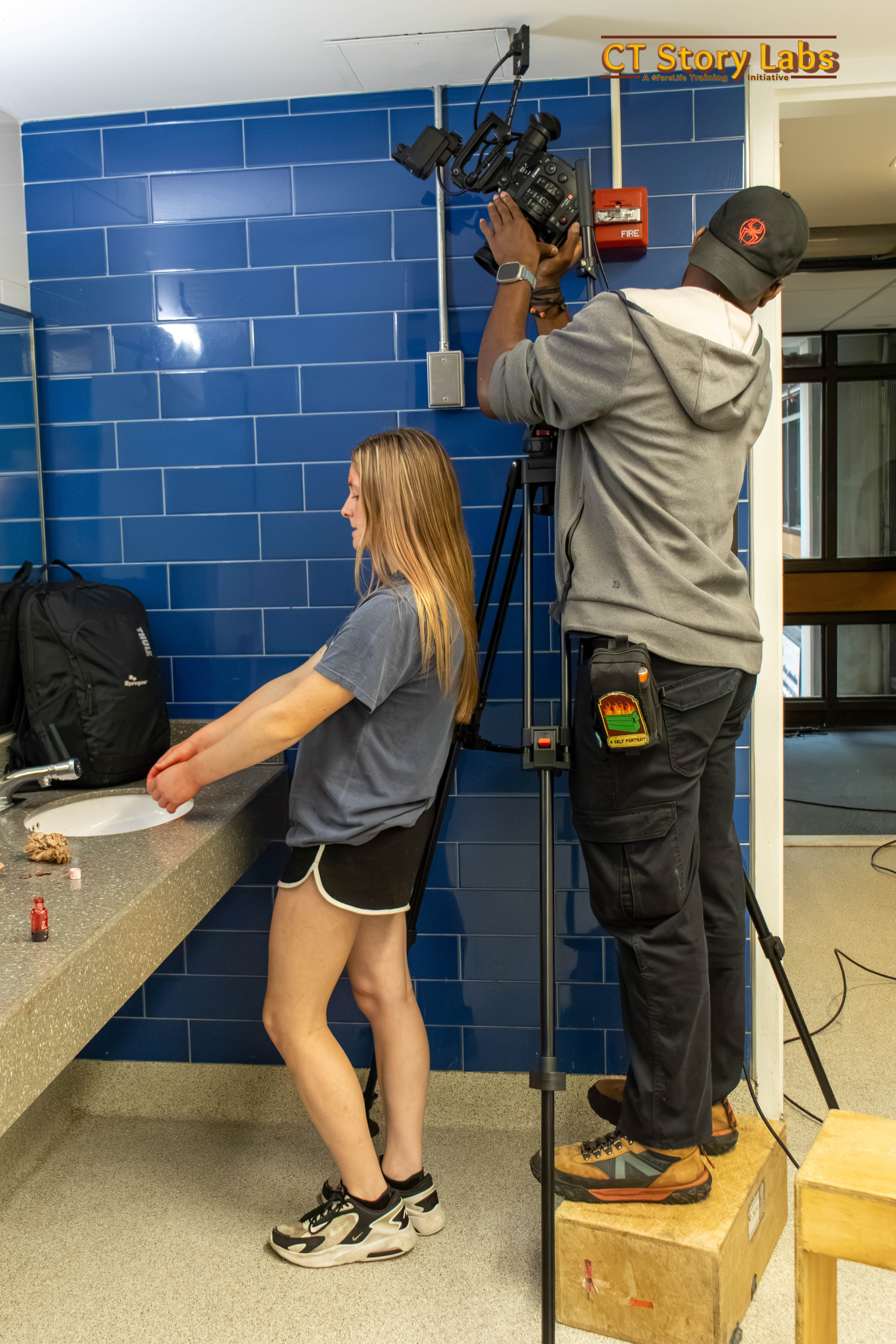 Young filmmakers on set operating a cinema camera while an actor performs