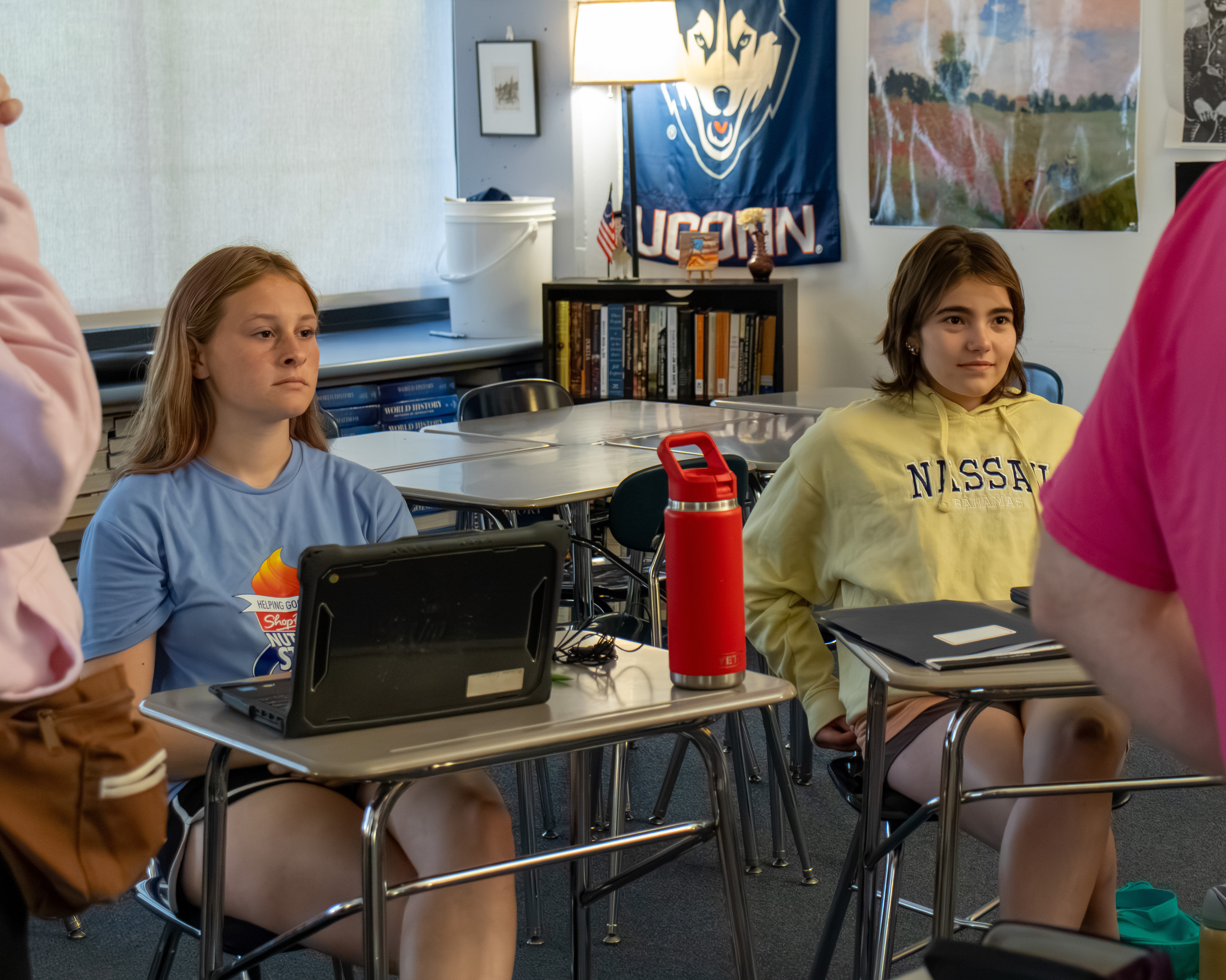 Two young writers at their desks listening intently during a session